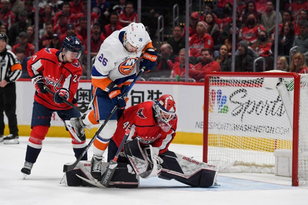 Washington Capitals målvakt Vitek Vanecek (41) gör en räddning medan New York Islanders högerforward Oliver Wahlstrom (26) kämpar om positionen framför målet under den andra perioden i matchen mot New York Islanders i Capital One Arena i Washington D.C., den 15 mars 2022. (Foto: All-Pro Reels)