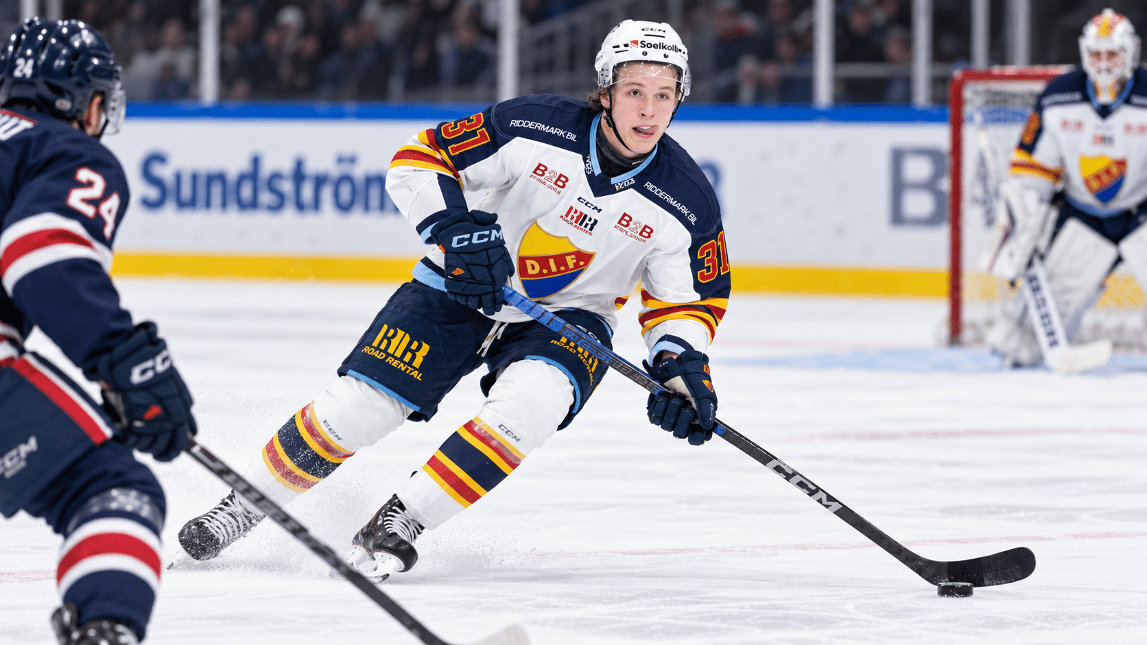 Fred Nord i Djurgårdens matchtröja under en ishockeymatch, där han för pucken framåt på isen med en motståndare framför sig.